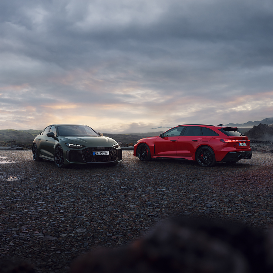 Ein blauer Audi Q6 e-tron in der Dreiviertelansicht von vorne bei der Fahrt auf einer Straße